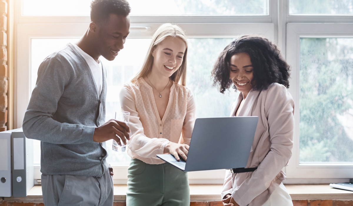 Three employees looking at computer